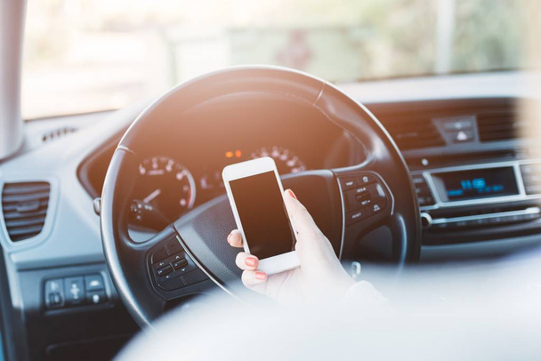 Mujer usando teléfono inteligente blanco en el coche
 - Foto, Imagen