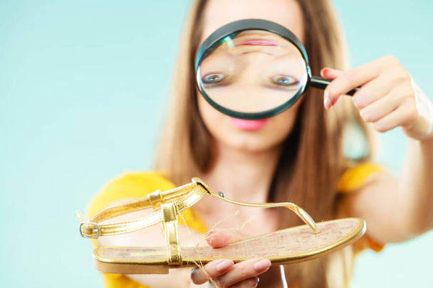 woman choosing shoes searching through magnifying glass - Zdjęcie, obraz
