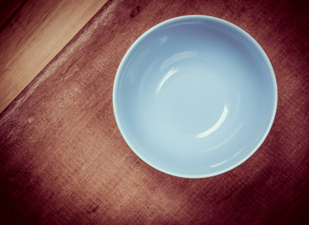 Okrągły talerz z niebieskim na drewnianym stole - Zdjęcie, obraz