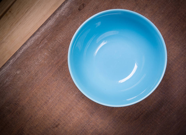 Kerek tányér, kék fa asztallal - Fotó, kép