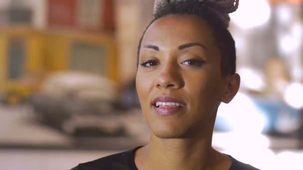 An attractive African American millennial woman smiles and looks at the camera - Video