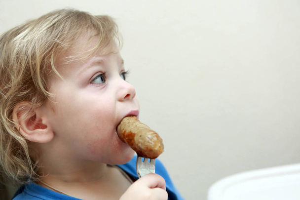 Kid eating sausage - Photo, Image