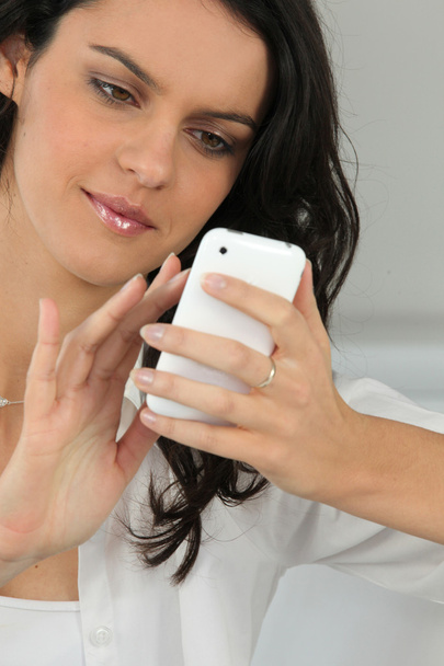 Young woman using a touch screen phone - Φωτογραφία, εικόνα