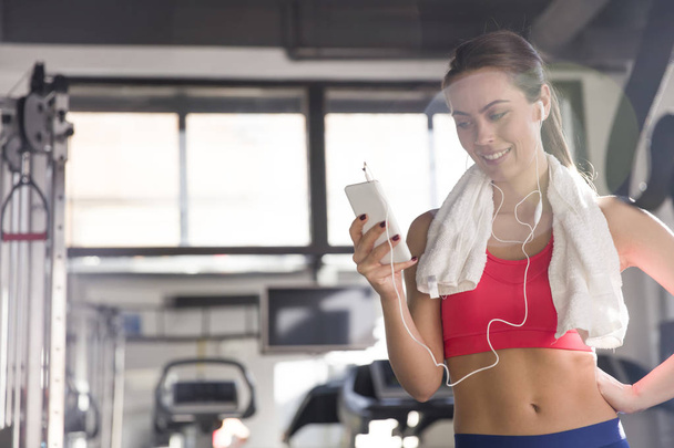 Kobieta za pomocą smartfona w siłowni - Zdjęcie, obraz