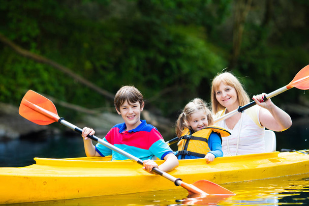 Perhe nauttii kajakki ratsastaa joella
 - Valokuva, kuva