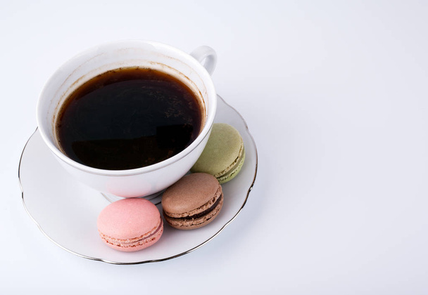 Bögre kávé és sütemény macaron fehér háttér, édes, színes desszert - Fotó, kép