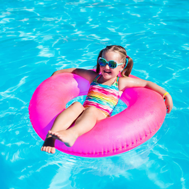 Little girl with toy ring in swimming pool - Foto, afbeelding