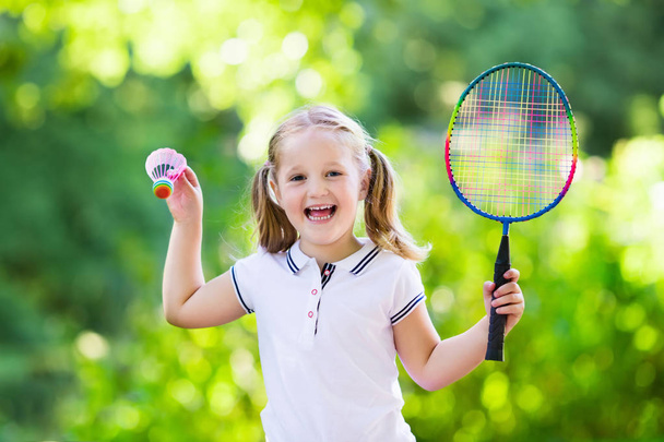 Niño jugando al bádminton o tenis al aire libre en verano
 - Foto, imagen