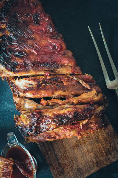 Delicious barbecued ribs seasoned with a spicy basting sauce - Foto, afbeelding