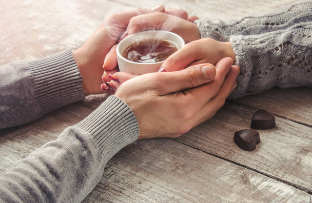 lovers holding together a Cup of tea. Selective focus.  - 写真・画像