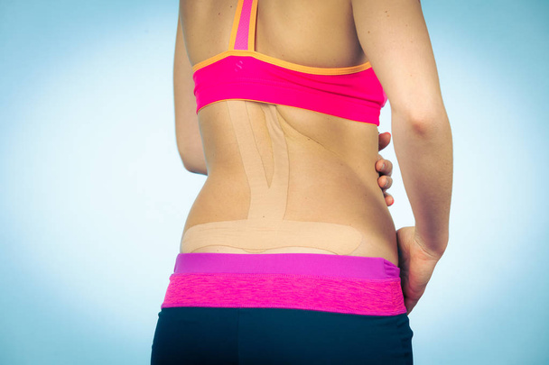 Woman with medical kinesio taping on back - Foto, imagen