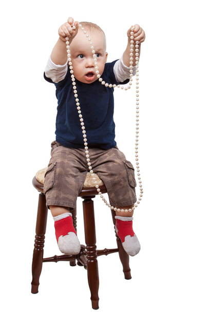 Мальчик играет в жемчужное ожерелье
 - Фото, изображение