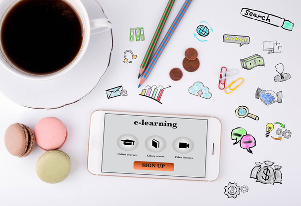 Pojem e-learning. Mobilní telefon a šálek kávy na bílý kancelářský stůl - Fotografie, Obrázek