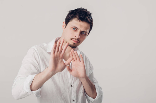 young man with dark hair in white shirt closed with hands on gra - Fotografie, Obrázek