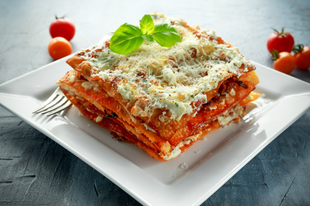 Homemade Crispy lasagna in iron pan with minced beef bolognese sauce, parmesan cheese and basil - Photo, Image
