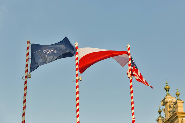 Drapeaux de l'OTAN, de la Pologne et des États-Unis en plein air contre un ciel bleu clair
. - Photo, image