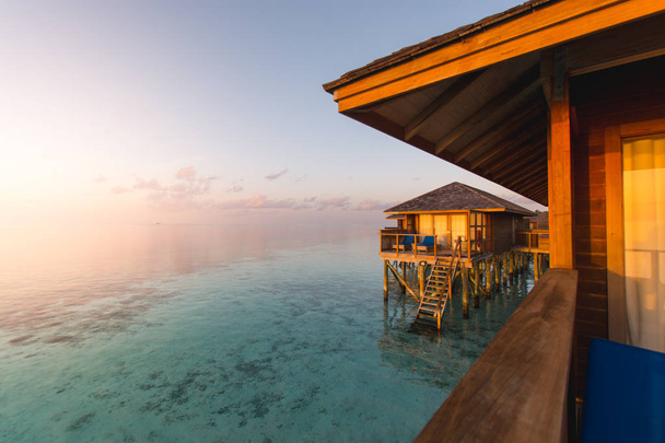 Kaunis trooppinen Malediivit keinona hotelli ja saari rannalla ja merellä taivaalla auringonlaskun loma tausta käsite - Boost up väri Processing
. - Valokuva, kuva