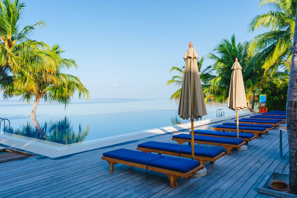 Bellissimo ombrellone di lusso e sedia intorno alla piscina all'aperto nel resort dell'hotel - concetto di vacanza per lo sfondo - Aumentare l'elaborazione del colore
. - Foto, immagini