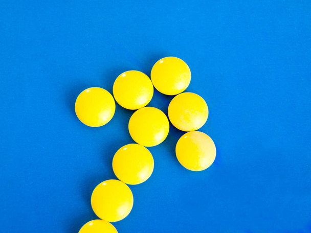 Yellow pills on a blue background - Photo, image