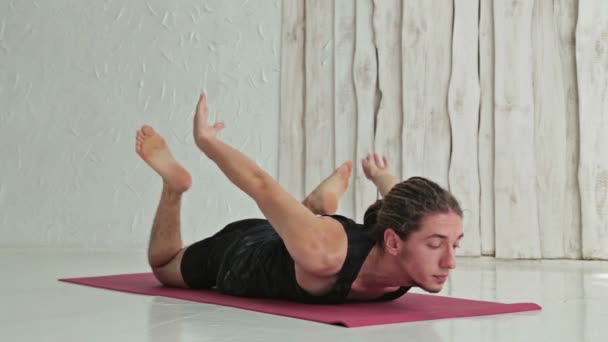 Young sporty man practicing ashtanga yoga in fitness studio - Footage, Video