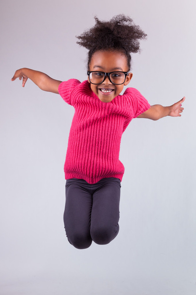 Portrait of Young African American girl jumping - Фото, изображение