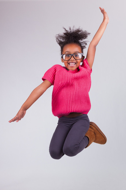 Portrait of Young African American girl jumping - Photo, image