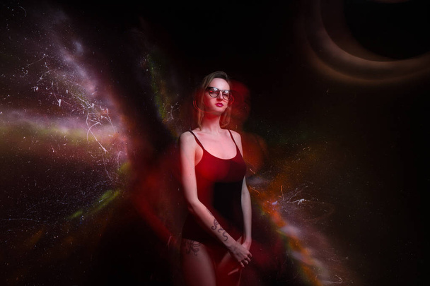 Beautiful girl in black bathing suit and round glasses isolated black cosmos background. Space concept art. Mixed light. Fashionable lighting effects. Crazy fashion idea - Foto, Bild