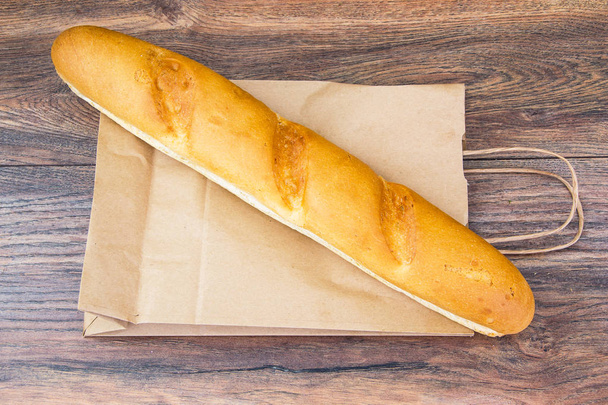 French baguettes in paper bag isolated on light background. Stock