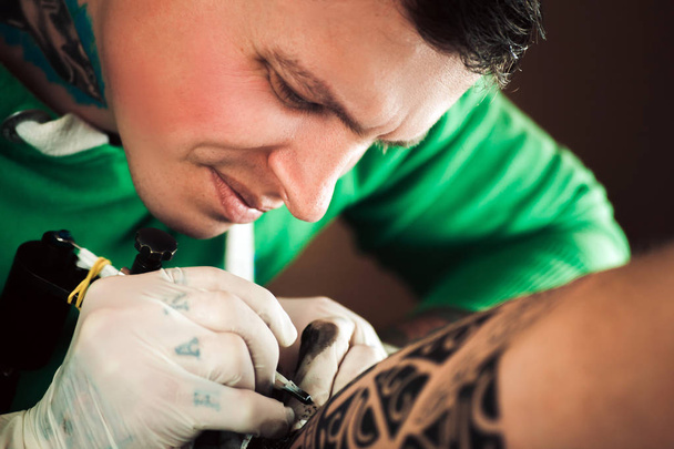 Master tattoo artist in gloves makes tattoo on hand men - Foto, imagen
