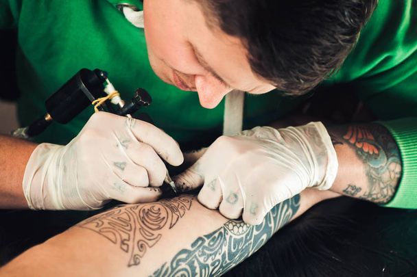 Master tattoo artist in gloves makes tattoo on hand men - Φωτογραφία, εικόνα