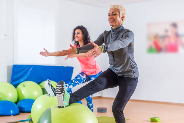 Duas mulheres fazendo exercícios na aula de aeróbica
 - Foto, Imagem
