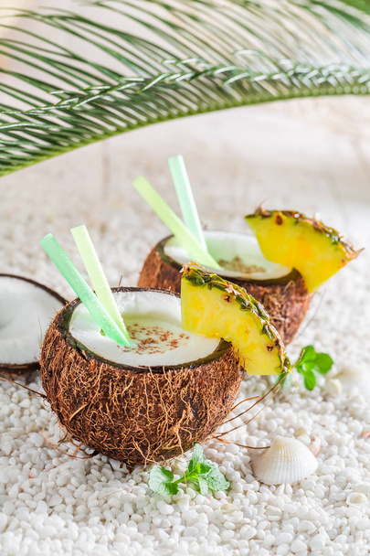Fresh pinacolada in coconut with pineapple and mint leaves - Foto, afbeelding