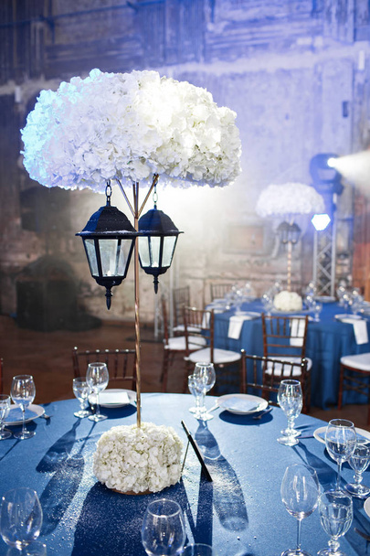 Svatba. Banket. Židle a kulatý stůl pro hosty, podávaný s příbory a nádobí a pokryté modrý ubrus. - Fotografie, Obrázek