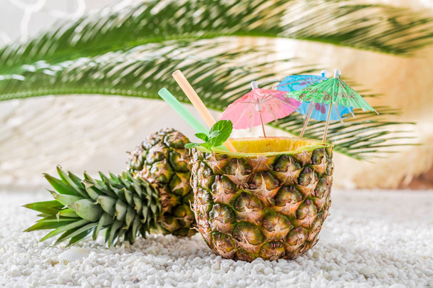Bebida tropical en piña en la playa de arena
 - Foto, imagen