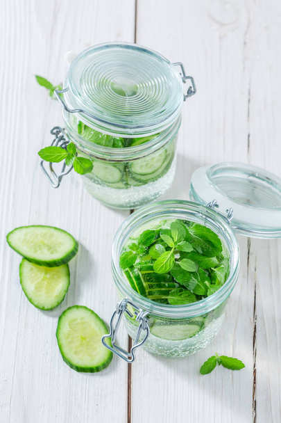 Healthy water in jar with cucumber and mint leaves - Foto, Bild