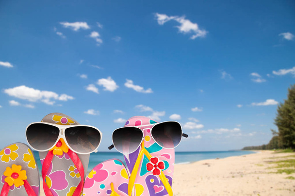 beach shoes with sunglasses on tropical sea and sky background. - Photo, Image