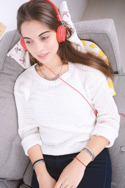 Woman listening music on couch. - Фото, зображення