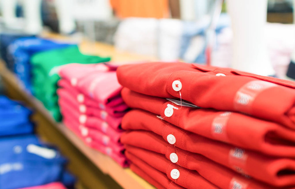 Fila de camisas coloridas em uma loja
 - Foto, Imagem