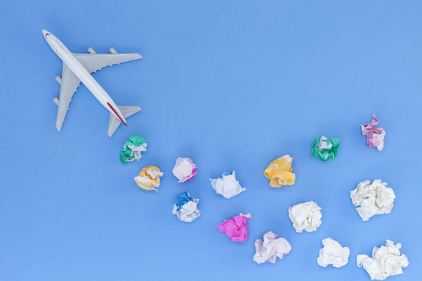 Airplane modell különböző papír labda a kék háttér  - Fotó, kép