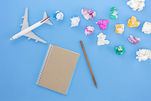 Airplane model with colorful blank paper note on blue background - Photo, Image