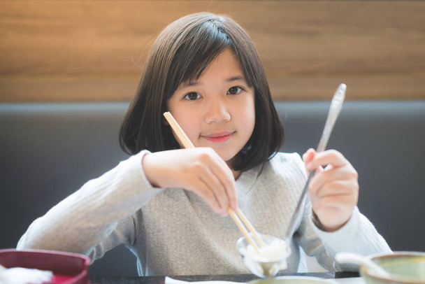 Chica asiática comiendo sukiyaki
  - Foto, Imagen
