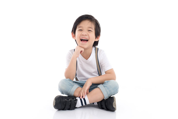 azjatycki chłopiec siedzi na białym tle  - Zdjęcie, obraz