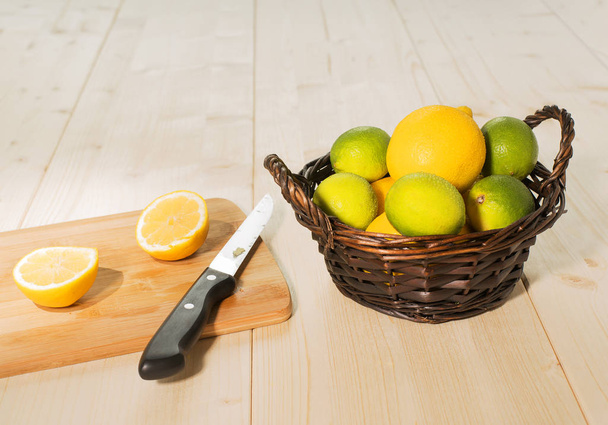 process of cutting of citrus, lemons and limes in a wicker basket  - Fotó, kép