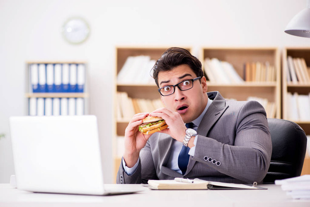 Hambriento empresario divertido comer sándwich de comida chatarra - Foto, imagen
