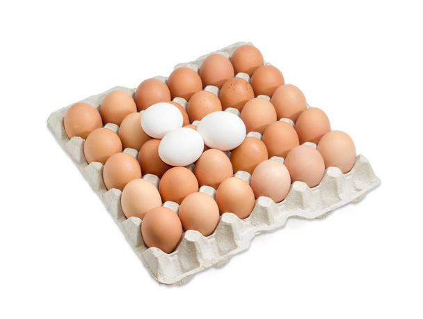段ボールの卵トレイに茶色と白の卵 - 写真・画像