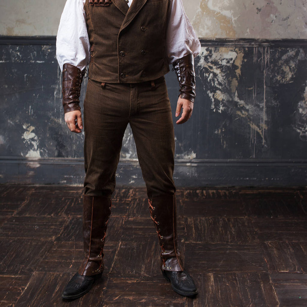 Handsome male Steam punk. Retro man over grunge background. Suit, pants and jacket, leather accessories - Fotó, kép