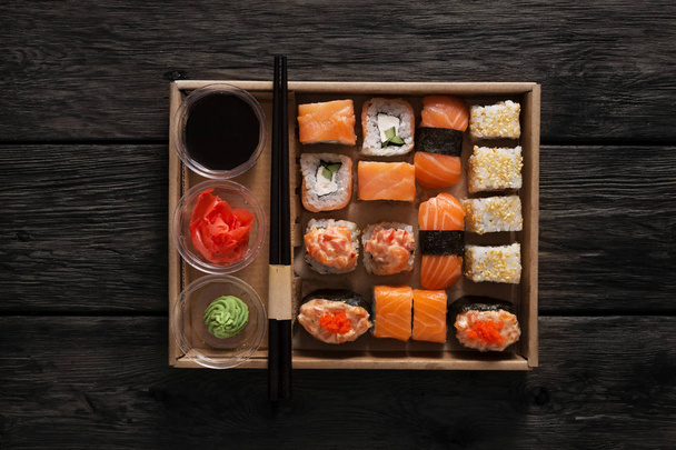 Set de sushi maki et rouleaux en bois rustique noir
. - Photo, image