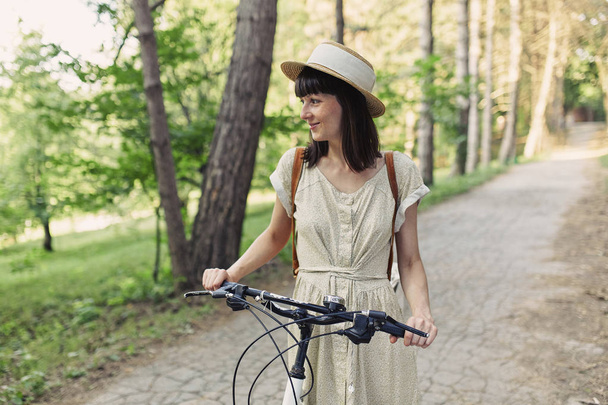 Young woman against nature background with bike - Foto, imagen