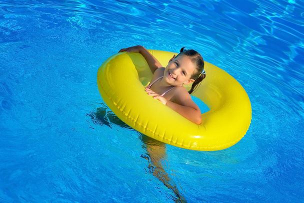 Real toddler girl relaxing at swimming pool - Fotó, kép