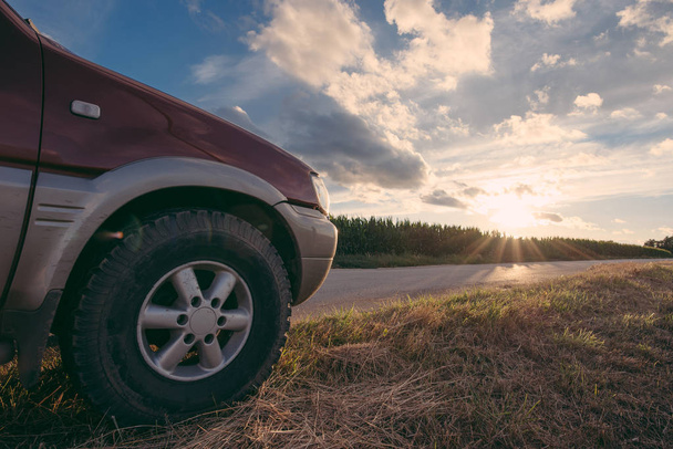 Journey concept. Off road vehicle on the rod at sunset outdoor. - 写真・画像